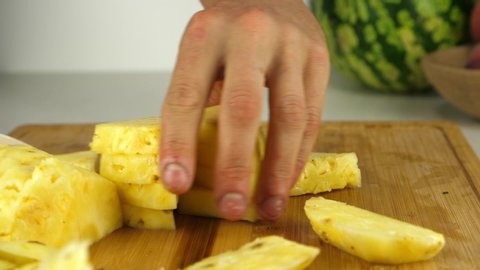 Slicing chunks of fresh pineapple with a sharp ceramic knife