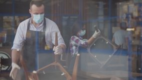 View through window of team waiters in facial mask closing cafe because of quarantine. Restaurant staff cleaning and arranging furniture after closing in evening. Small business and pandemic concept - Powered by Shutterstock - Get 15% off with code: PIKWIZARD15