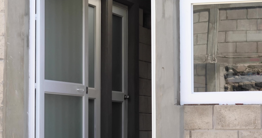 young man leaving home and locking the door, putting on his face mask.