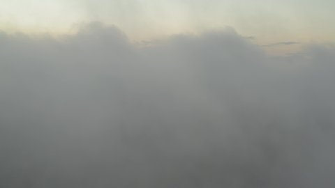 Ascending above thick fog during sunrise 4K