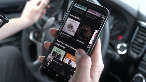 Browsing Spotify music streaming app on a smartphone while being in a car listening to music. MONTREAL CANADA JUNE 2020