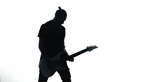 Silhouette of guitarist playing electric guitar
