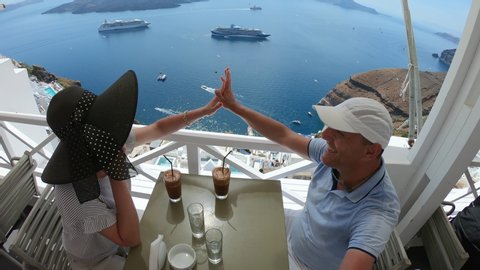 Santorini, Couple refresh with coffee, water, juice served on the balcony with sea view.