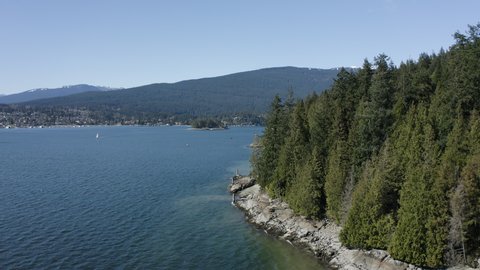 Drone over water in British Columbia (BC). West coast sunny day along the Indian Arm with mountains in the background