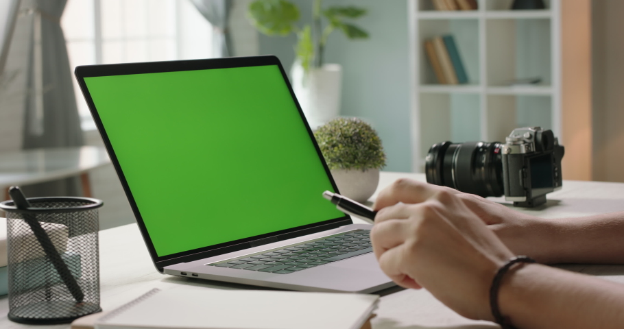 Close up shot of hands of student working with chroma key green screen laptop, using trackpad and pen with notebook in living room - technology concept 4k video template Royalty-Free Stock Footage #1056257153