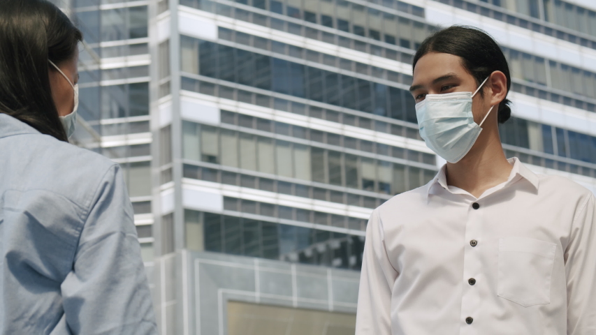 Elbow bumping. Two business people wear mask and greet each other in a new way to prevent the spread of germs and avoid virus covid-19 in the city Royalty-Free Stock Footage #1056261101