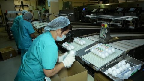 Chelyabinsk, chelyabinsk region / Russia - 07.20.2020: poultry workers are packing eggs into boxes.

Workers in special protective uniforms pack products from the conveyor.