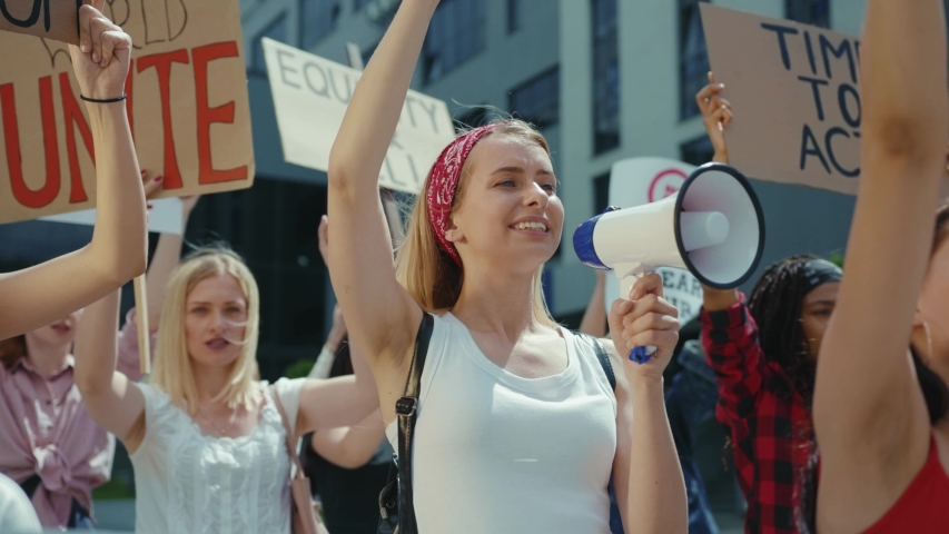 Group of strong powerful women participate in public street demonstration fighting for gender equality. Feminist manifestation. Girl power concept. Resistance. Royalty-Free Stock Footage #1056263930