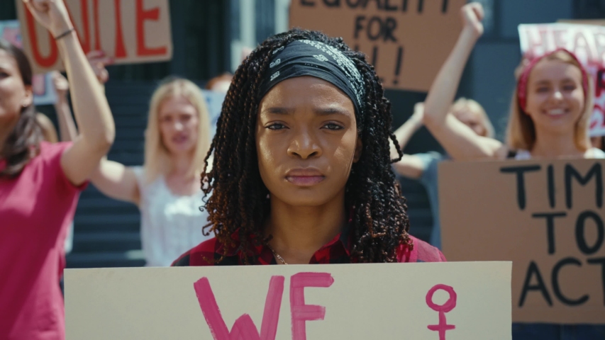 Afro-american woman showing We Can Do It poster on female protest. Crowd of resolute and strong women protesting for gender equality. Feminism promotion. Royalty-Free Stock Footage #1056263984