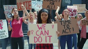 Afro-american woman showing We Can Do It poster on female protest. Crowd of resolute and strong women protesting for gender equality. Feminism promotion. - Powered by Shutterstock - Get 15% off with code: PIKWIZARD15