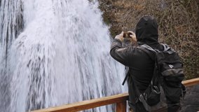 Hiker standing by waterfall outdoors in winter Cinemagraph