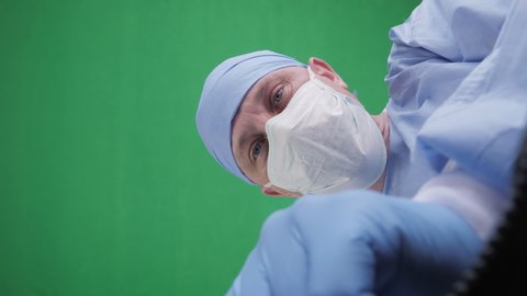 Doctor closes the plastic bag with a dead body inside. Hospital morgue, a corpse in a black plastic bag on green screen background. POV view, conceptual footage