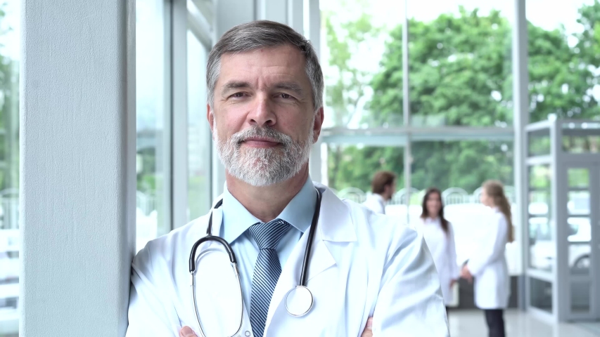 Confident thoughtful senior adult male professional medic, old doctor wears white medical coat, looking through window dreaming, thinking. Healthcare and medicine concept Royalty-Free Stock Footage #1056280328