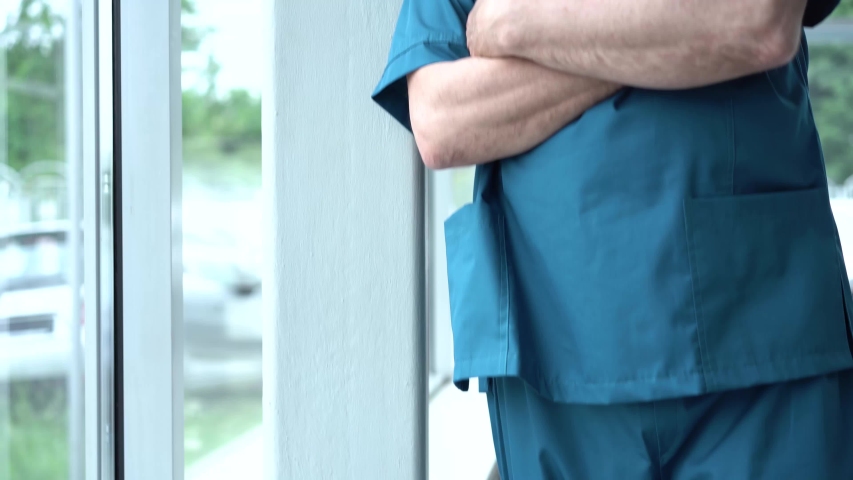 Confident thoughtful senior adult male professional medic, old doctor wears white medical coat, looking through window dreaming, thinking. Healthcare and medicine concept Royalty-Free Stock Footage #1056280355