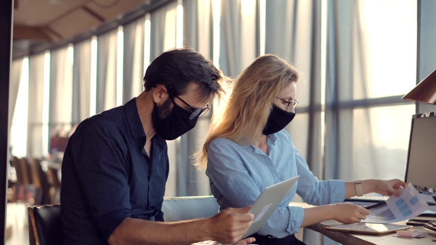 Two Colleagues Talking In Face Mask Office On Covid19 Coronavirus Pandemic Quarantine Lockdown. Coworkers Together In Lockdown Avoid Self Distance.Employee Cooperating In Working Together On Workplace Royalty-Free Stock Footage #1056292760