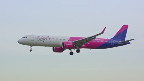BARCELONA, SPAIN - 2020: Wizz Air Airbus A321neo Jet Airliner Early Morning Arrival Flying into Barcelona-El Prat BCN International Airport from a Vibrant Colorful Sky Landing and Touching Down