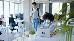 Young people with face masks back at work in office after lockdown, greeting. - Powered by Shutterstock - Get 15% off with code: PIKWIZARD15