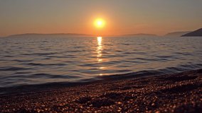 4K footage of a crimson sunset over the mediterranean sea. Show at Kovacine beach in cres island, croatia, on the adriatic sea