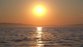 4K footage of a crimson sunset over the mediterranean sea. Show at Kovacine beach in cres island, croatia, on the adriatic sea