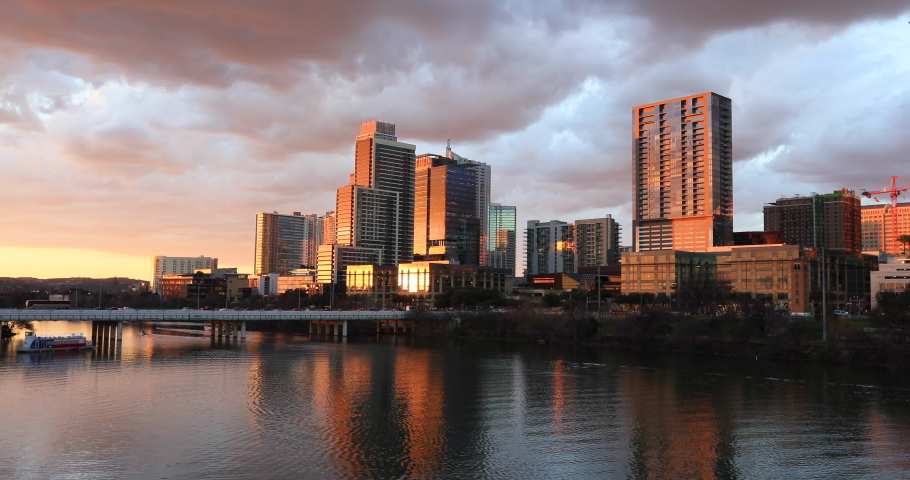 Austin Texas evening sunset across river city skyline. Brilliant sunset colors. Lady Bird Lake. Skyline of the city along the shore.