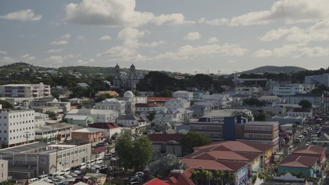 Aerial panning shot of cityscape under clouds / St. John's, Antigua