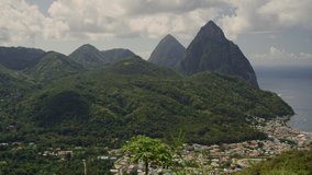 Aerial panning shot of mountains and distant houses at waterfront / St. Lucia