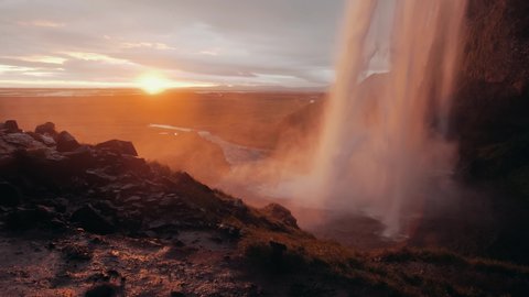 Slow motion shot of Seljalandsfoss at sunset, a famous waterfall in Icelandの動画素材