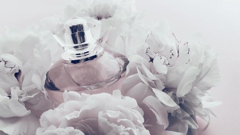 White perfume bottle with peony flowers, chic fragrance scent as luxury cosmetic, fashion and beauty product background, stock footage
