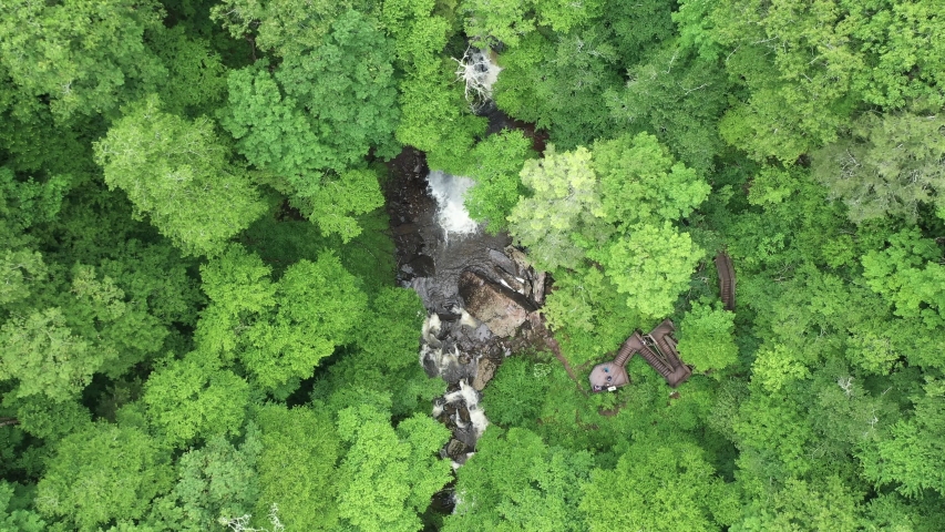 Aerial View of Waterfall Deep in the Middle of Forest. Top Down Descending Revealing Drone Shot