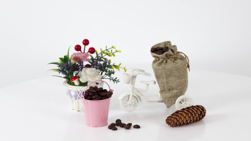 Cup of black coffee with coffee beans and bike toy on wooden table background.