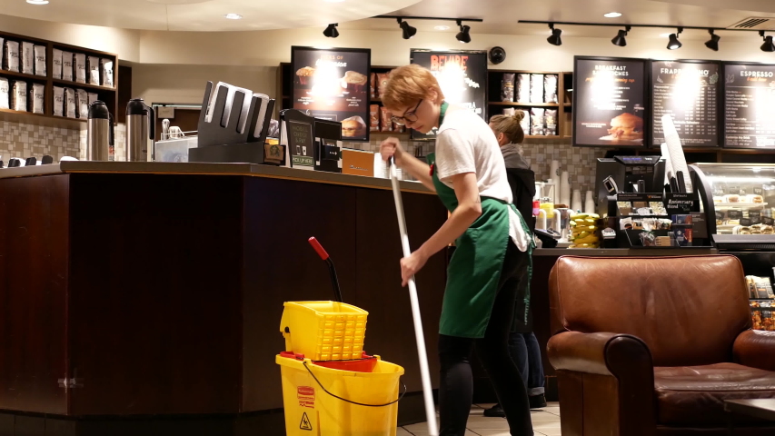 Port Moody, BC, Canada - October 28, 2016 : Motion of worker cleaning floor inside Starbucks store with 4k resolution. | Shutterstock HD Video #1056311231