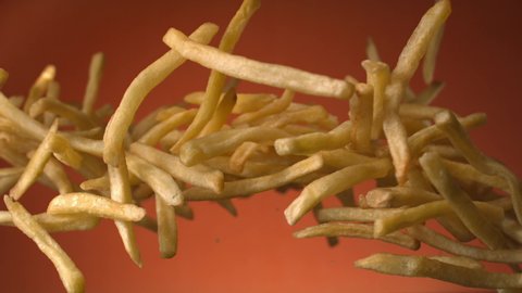 Potato French Fries Flying in the Air on a Terra Cotta Background Shot on Phantom 4K