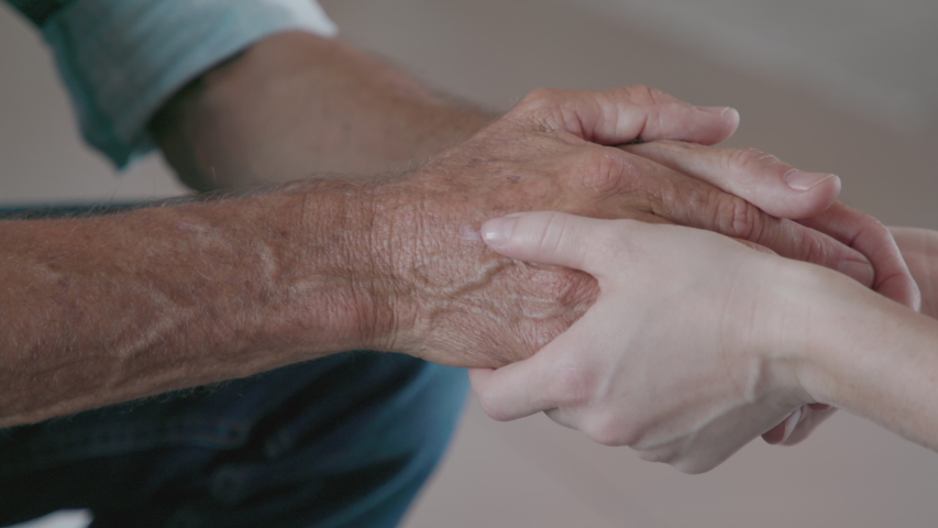 Close up of daughter hands holding father hands. Detail hand of woman consoling old man. Helping hands, care and elderly comfort concept | Shutterstock HD Video #1056320276