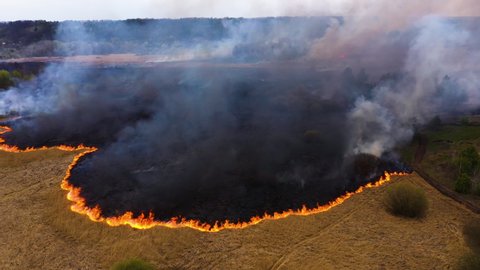 Aerial view of wildfire and smoke in Siberia, Russia. Siberian forest fire. Natural disaster, fire Field burning in summer. Ecology concept 2020
