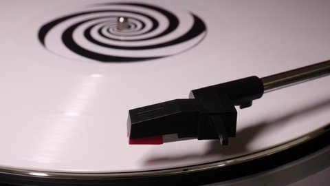 Stylus arm and needle lowered on 12” white vinyl record on a DJ turntable. Retro LP platter. Close up. Popular music equipment for disco, punk, grunge, pop in 60s, 70s, 80s, 90s 4K