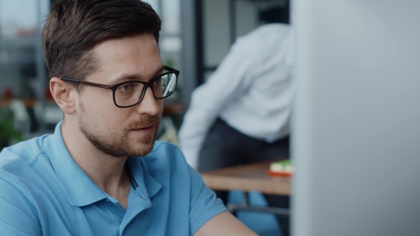 Cheerful caucasian office employee sharing great business news with boss team leader looking on computer screen in coworking space. Royalty-Free Stock Footage #1056322868