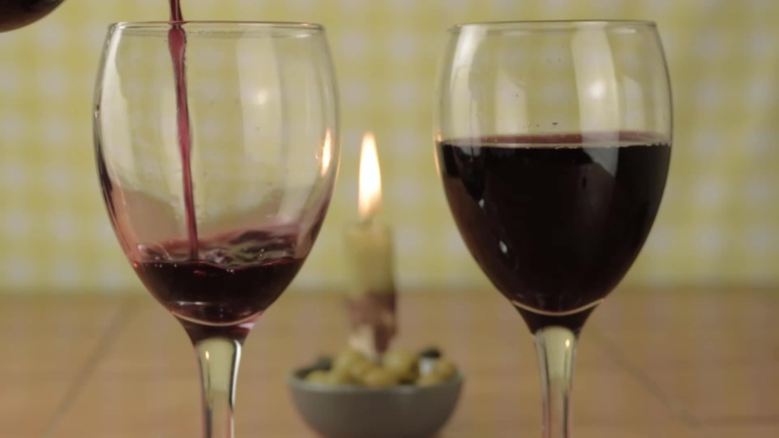 Pouring red wine into a glass with candle medium shot | Shutterstock HD Video #1056325064
