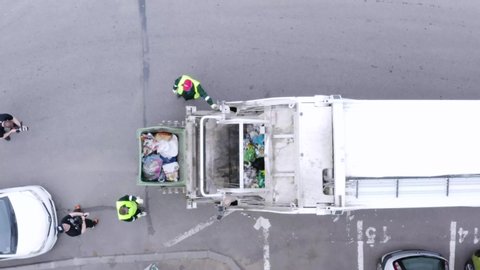 Cluj/Romania - June 2020: Aerial shot of garbage men with trash truck picking up the city garbage. Waste disposal