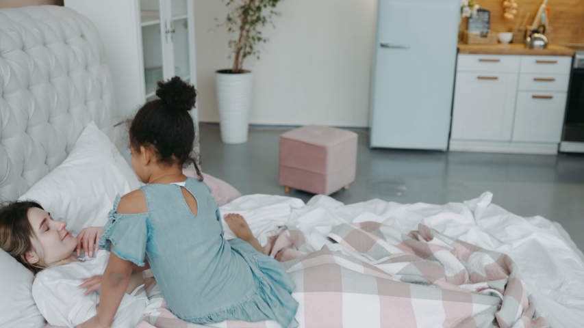 African little girl daughter in denim dress came to her mother