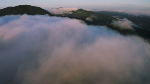 Morning mist over the mountain. Aerial view of fog above forest and mountains. Morning foggy smoke in magic rays light sun. 