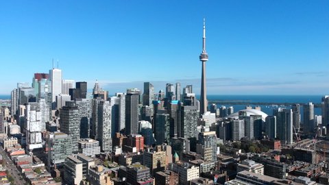 Aerial view of Toronto cityscape showing architectural landmark CN Tower and high-rise buildings in the financial district on a sunny day. 