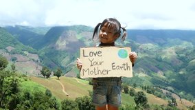 Child girl holding a nature conservation banner in the forest on mountain. The concept of World Environment Day. - Powered by Shutterstock - Get 15% off with code: PIKWIZARD15