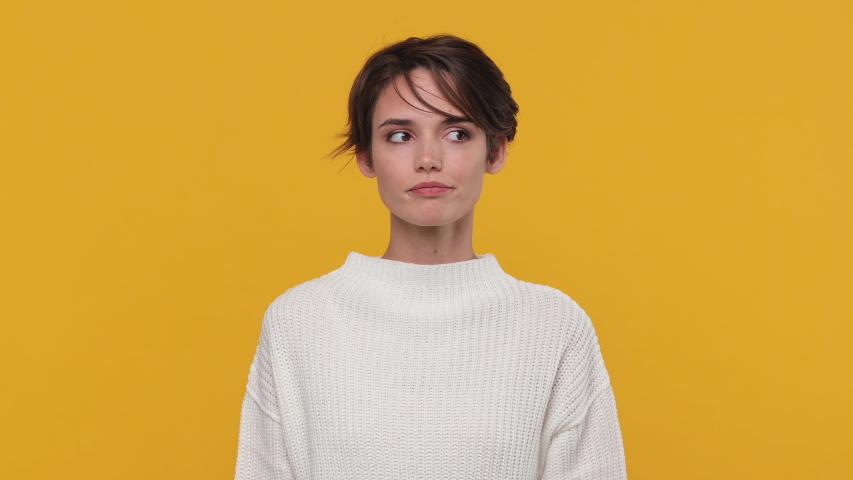 Boring beautiful young woman girl 20s years old in white sweater posing look around get hold using mobile cell phone isolated on yellow background in studio. People sincere emotions lifestyle concept Royalty-Free Stock Footage #1056346331