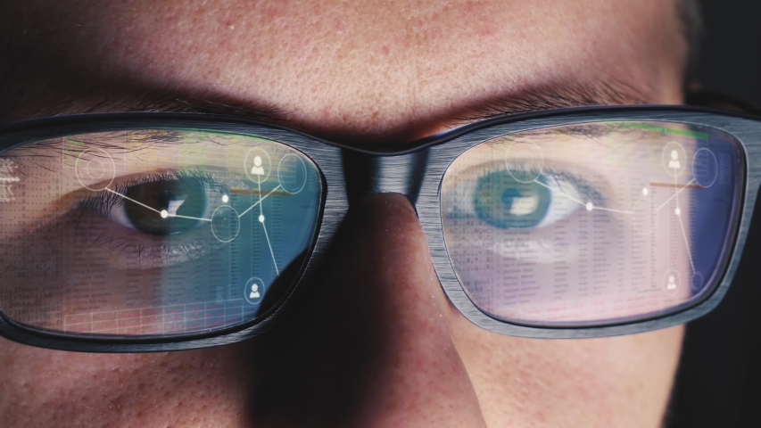 Man leans over to his computer screen and begins to code - Image is reflected on his glasses Royalty-Free Stock Footage #1056349034