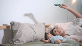 Asian Mother and her baby daughter are making selfie or video call to father in bed , Family , Home safety , parenthood , technology concept