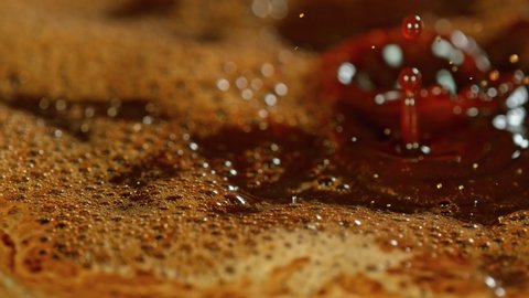 Super Slow Motion Macro Shot of Splashing Fresh Coffee and Water Droplets at 1000 fps.