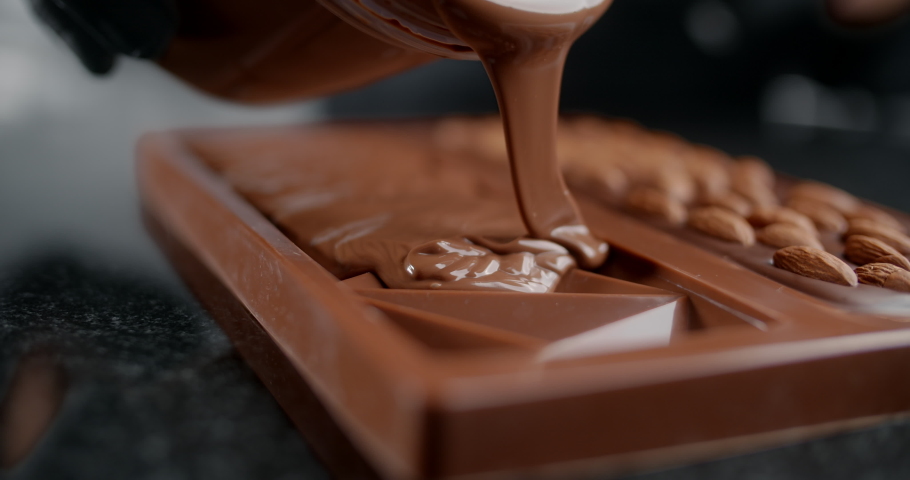 Chef confectioner makes chocolate bar - he pours hot melted chocolate to the silicone form, art of handmade chocolate, cooking desserts from chocolate and cocoa, making bars, 4k 120 fps Prores HQ | Shutterstock HD Video #1056358757