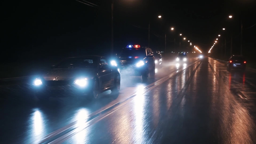 Cop cars are chasing an intruder's car in the rain. Outdoor front view of police traffic auto driving. Shot on the Russian Arm. Royalty-Free Stock Footage #1056359729
