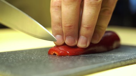 red pepper cutting process. A man holds a vegetable in his hands. Close-up view. Horizontal shot of male hands cutting red pepper vegetable