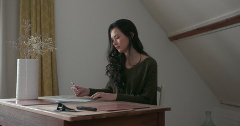 Young woman writing letter at desk